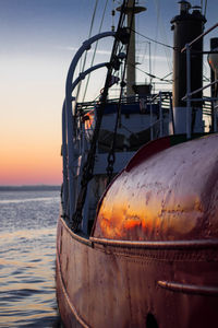 Close-up of ship against sky during sunset