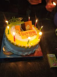 Illuminated candles on birthday cake