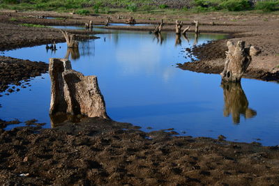 Scenic view of rocks by lake against sky