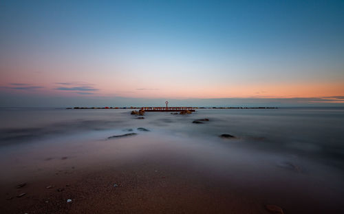 Scenic view of beach against sky during sunset