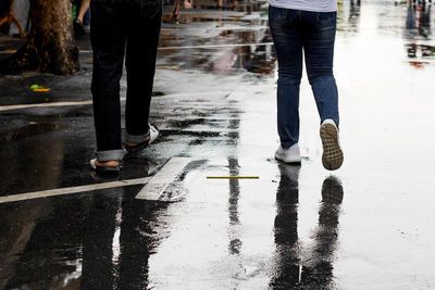 Low section of man walking on puddle