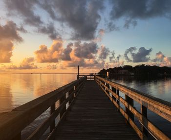 Pier over sea against sky during sunset