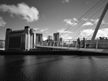 City at waterfront against cloudy sky