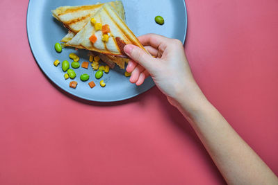 High angle view of hand holding food on table