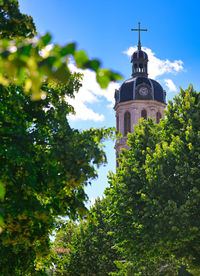 Low angle view of trees and building against sky