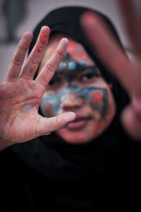 Close-up portrait of woman with hands