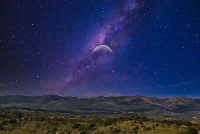 Scenic view of mountains against sky at night