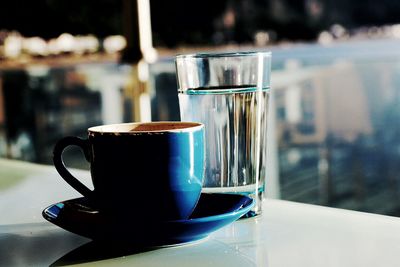 Close-up of tea cup and water on table