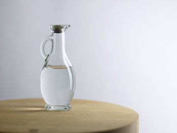 Water in jug on table against white background