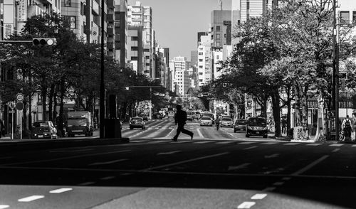 Man walking on street amidst buildings in city