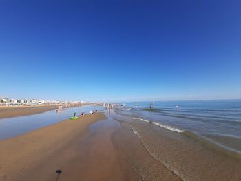 Panoramic view of beach against clear blue sky