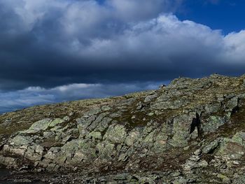 Low angle view of rocks on mountain against sky