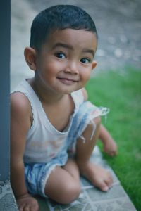 Portrait of cute boy sitting outdoors