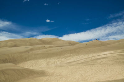 Scenic view of desert against blue sky