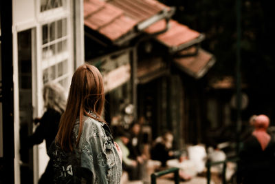 High angle view of woman standing by house in city