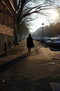 Rear view of silhouette man walking on road