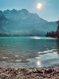 Scenic view of sea and mountains against sky