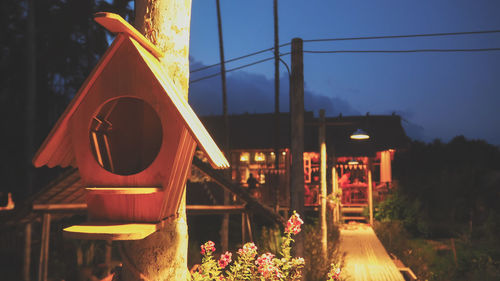 Close-up of illuminated sign against sky at dusk