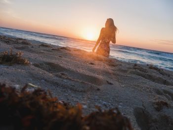 Silhouette of woman on a beach at sunset