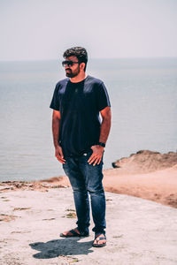 Full length of young man standing on beach