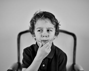 Close-up of thoughtful boy looking away while sitting on chair