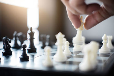 Cropped hand of man playing chess