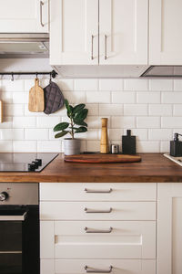 Kitchen brass utensils, chef accessories. hanging kitchen with white wall and wood tabletop.