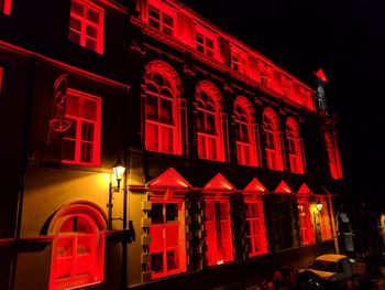 Red illuminated building at night