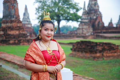 Portrait asian woman in thai dress with ancient ruin temple background