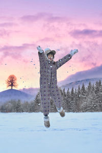 Full length of woman standing on snow covered landscape