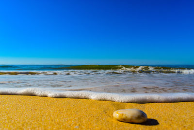 Surface level of beach against clear sky