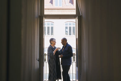 Senior couple with coffee cup spending leisure time in balcony at home