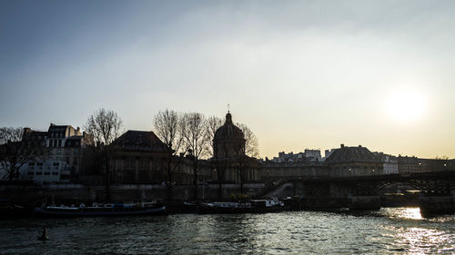 River with buildings in background at sunset