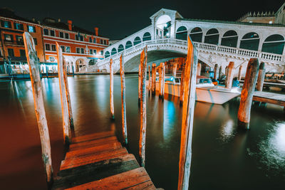 Arch bridge over canal amidst buildings in city