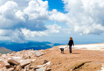 Woman walking with dog on mountain