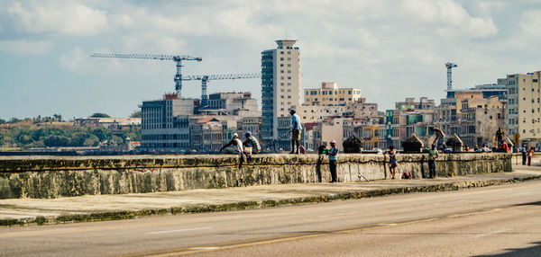 View of city street against cloudy sky