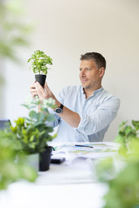 Side view of young man holding bouquet