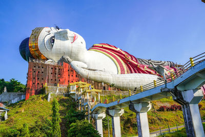 Low angle view of sculpture on building against sky