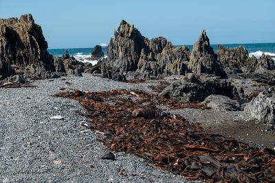 Rock formations on beach against clear sky