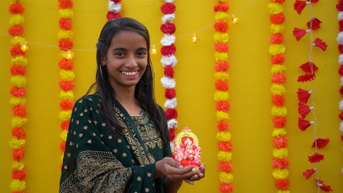 Young indian girl with lord ganesha, celebrating ganesh festival or diwali festival.