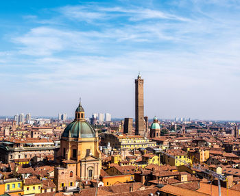 Church and buildings in city against sky