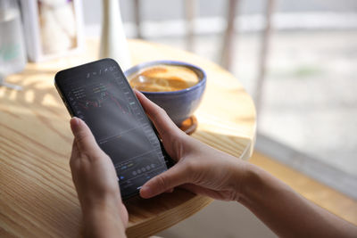 Cropped hands of woman using mobile phone