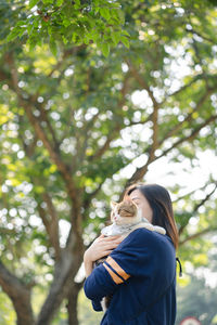 Asian woman feel happy during relax and play with her cat at park