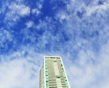 Low angle view of modern building against cloudy sky