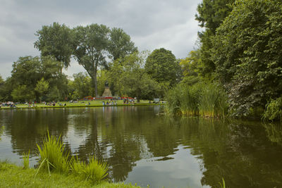 Scenic view of lake by trees against sky