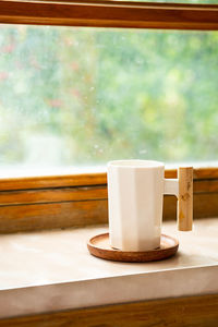 White mug on wooden windowsill. cozy loneliness breakfast at home.