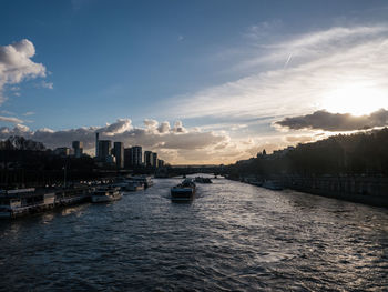 Panoramic view of river amidst buildings in city against sky