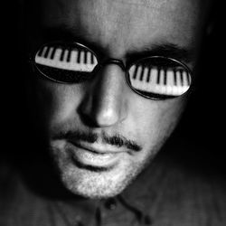 Close-up of man with piano reflected in sunglasses