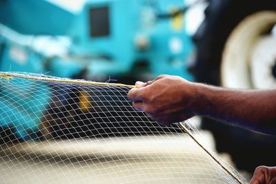 Cropped hand of fisherman holding fishing net