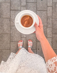 Low section of woman holding coffee